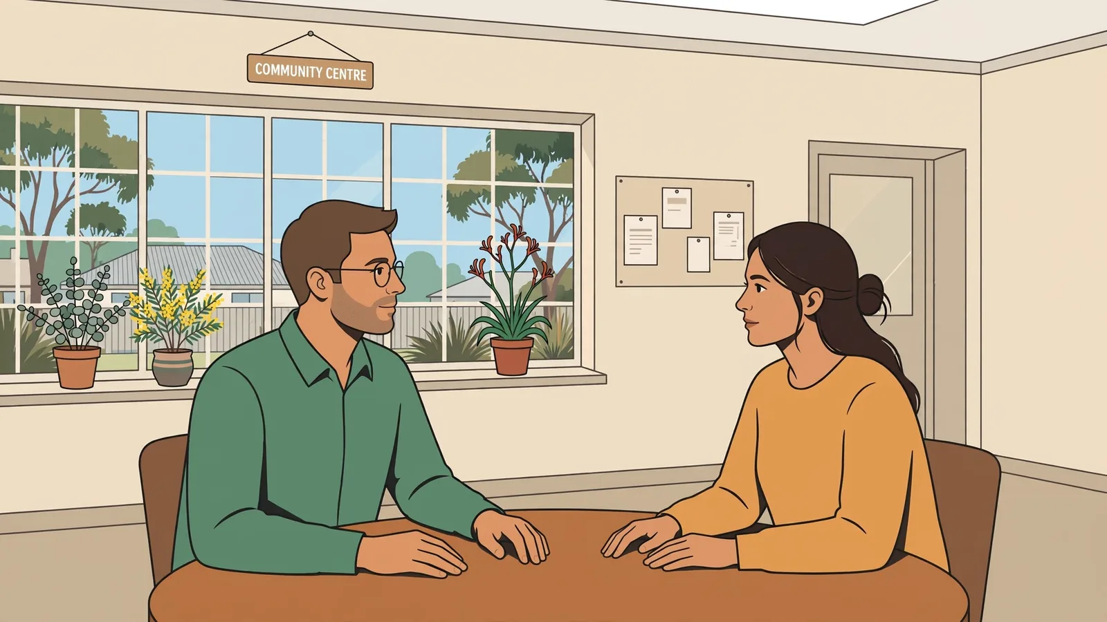Counsellor speaking with a visitor at a community centre table.